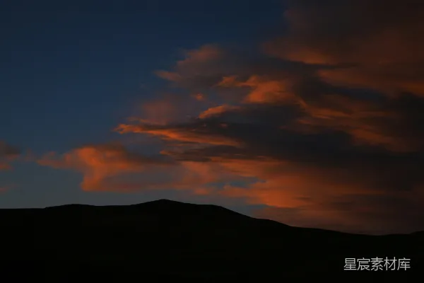 高清摄影 日落背景有云和山峰。