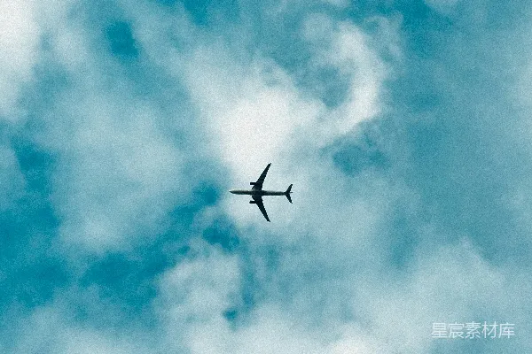 高清摄影 一架飞机在一片云层中穿越蔚蓝的天空