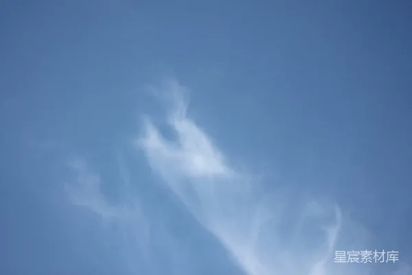 高清摄影 一架飞机在蓝色的天空中飞行，云朵飘荡其间。