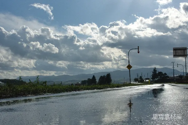 高清摄影 湿路反射着云层天空和远处的山峦