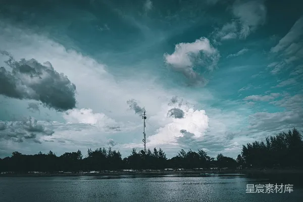 高清摄影 工业烟囱在云层覆盖的天空下向水中排放烟雾。
