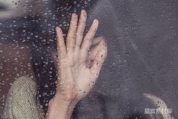 高清摄影 女人触摸着雨淋的玻璃。