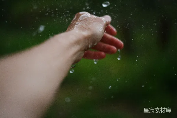 高清摄影 一个人伸手去拿雨中的东西。