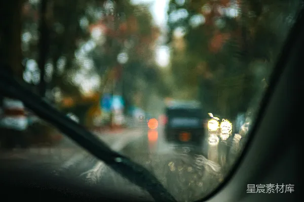 高清摄影 透过雨天的挡风玻璃看模糊的交通灯。