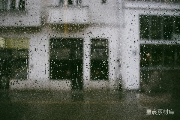 高清摄影 雨中的一扇窗户，背景是建筑物。