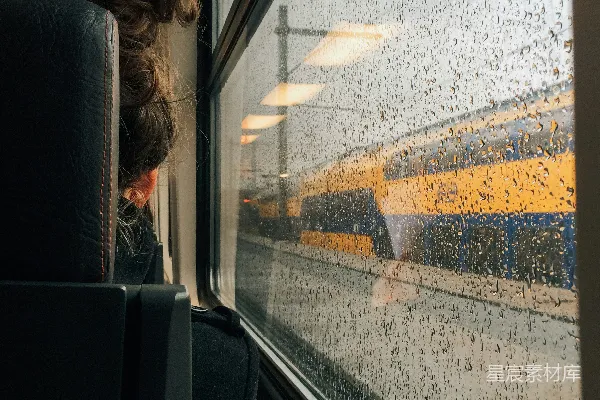 高清摄影 一个女人在雨天透过火车车窗向外看。