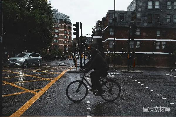 高清摄影 一个男子在一条雨水浸湿的街道上骑自行车。