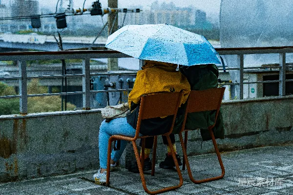 高清摄影 穿着蓝色直筒牛仔裤的女人坐在棕色木椅上，手中拿着伞。