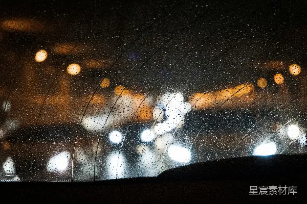 高清摄影 雨淋的车窗后有街灯在背景中。