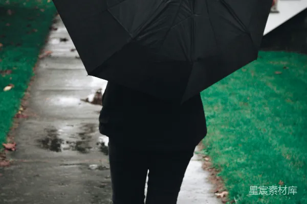 高清摄影 一个人在一条人行道上打着伞行走