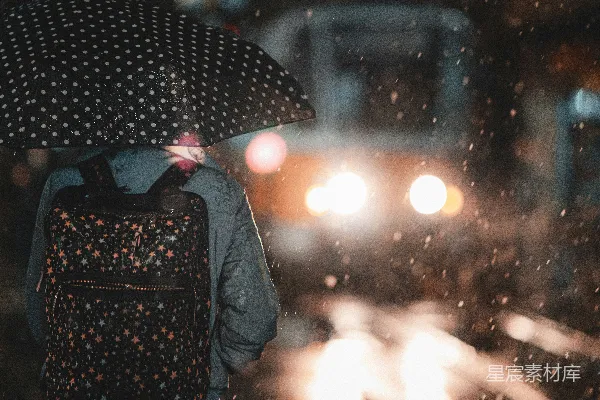 高清摄影 背着背包打着伞的人在雨中行走