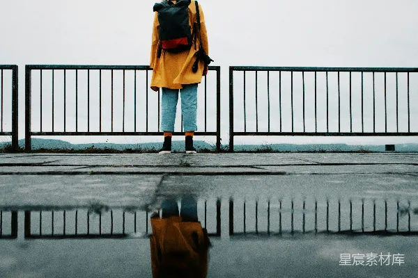 高清摄影 穿棕色夹克和蓝色牛仔裤的女人正在桥上行走。