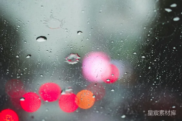 高清摄影 雨中的一张模糊街道照片，有交通灯在其中。
