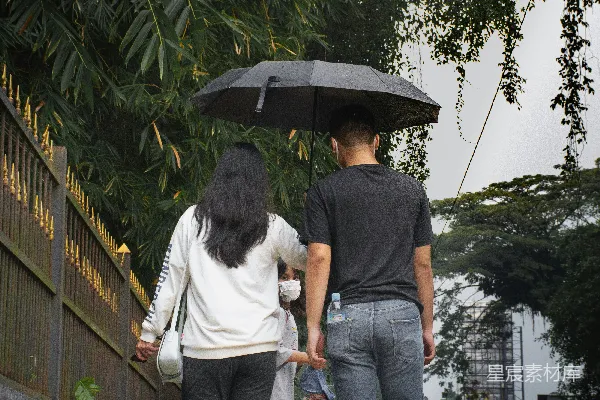 高清摄影 一个男人和一个女人打着伞走在路上。