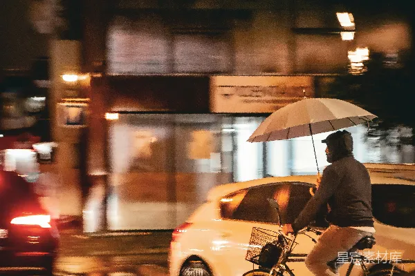 高清摄影 一个男子在雨中骑自行车撑着伞