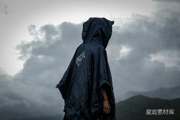 高清摄影 黑色雨衣的人在雨中漫步。