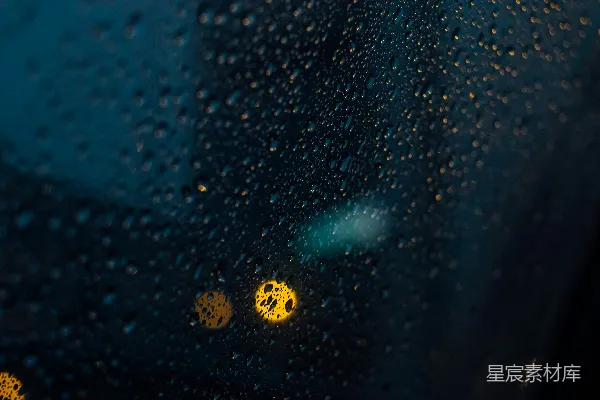 高清摄影 雨滴落在有黄色灯光的玻璃窗上
