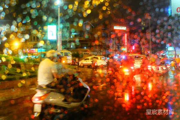 高清摄影 一个男人在一条被雨水浸湿的街道上骑着摩托车。