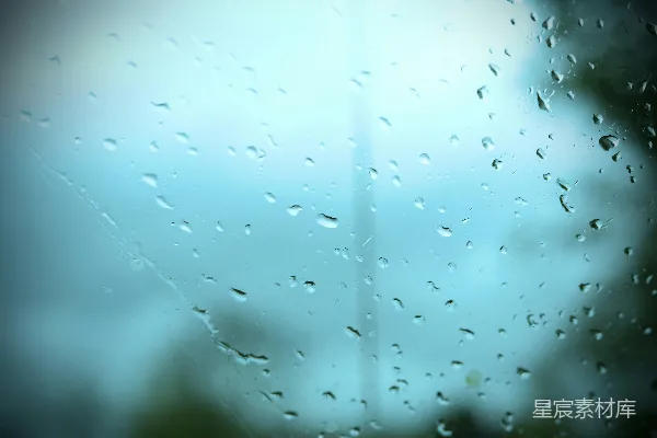 高清摄影 玻璃窗上的雨滴创造了一个模糊的蓝色景象。