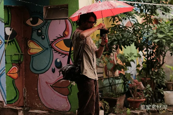 高清摄影 一个男人手持红色雨伞站在建筑物前