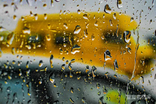 高清摄影 雨淋湿的窗户旁边有一辆校车。