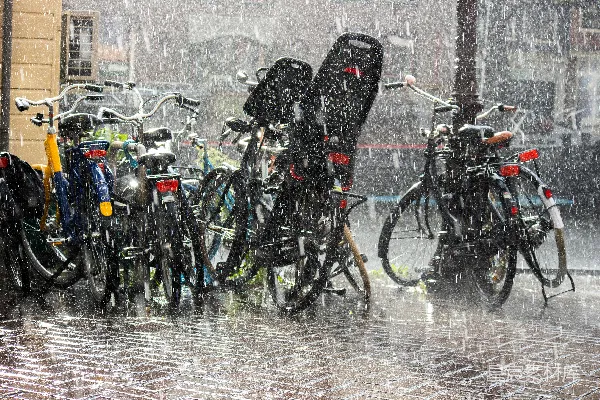 高清摄影 一排自行车挤在一起，在雨中停放着。