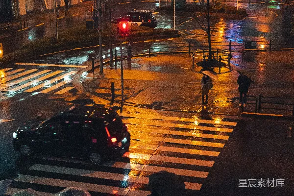 高清摄影 夜晚持伞的人们穿过湿漉漉的街道。