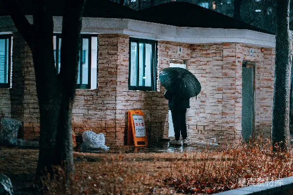 高清摄影 黑色夹克的人白天站在棕色砖砌建筑物附近。