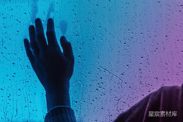 高清摄影 站在窗前的人被雨水覆盖着。