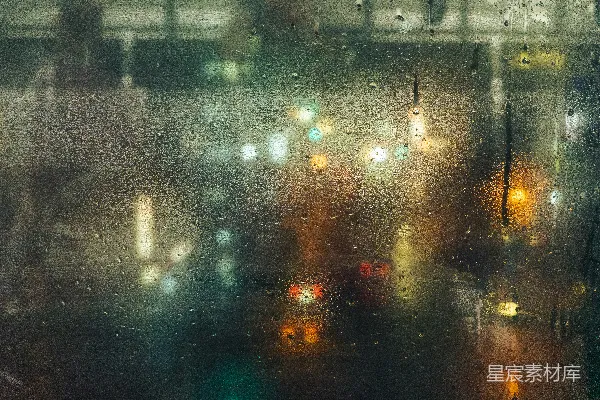 高清摄影 雨滴落在玻璃上，映着模糊的城市灯光
