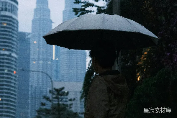 高清摄影 撑伞的男人望着雨中城市的天际线。