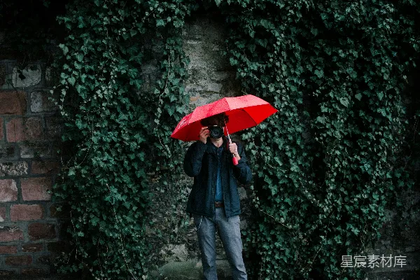 高清摄影 穿着黑色夹克的男人手持红色雨伞