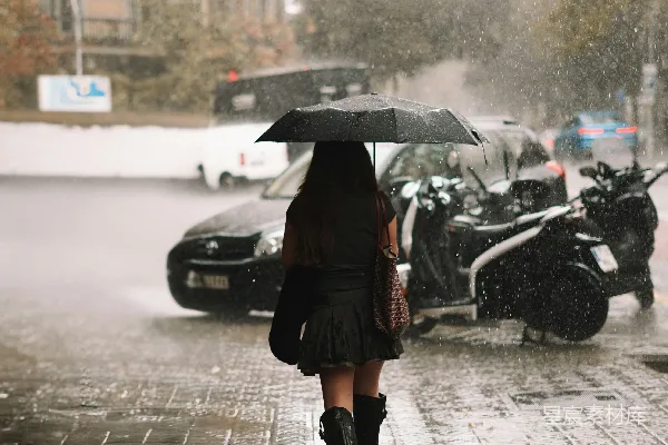 高清摄影 一个女人打着伞在雨中行走。