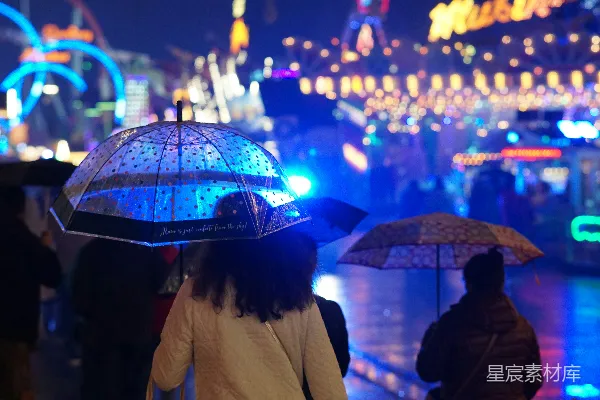 高清摄影 人们在一座明亮的嘉年华中使用雨伞。