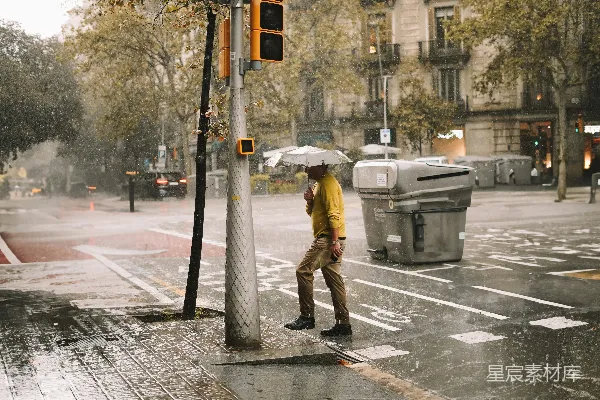 高清摄影 一个男子走在街上拿着雨伞。