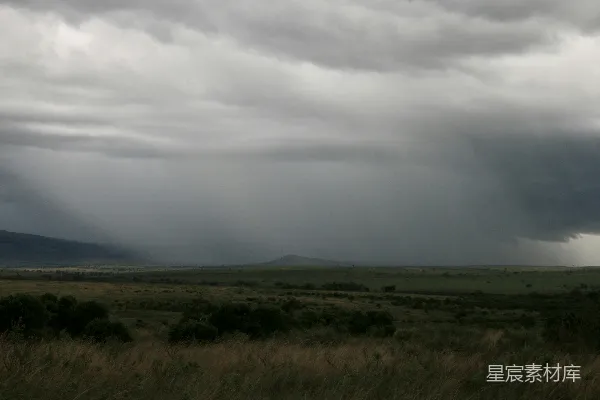 高清摄影 乌云聚集在一片广阔的草地上方。