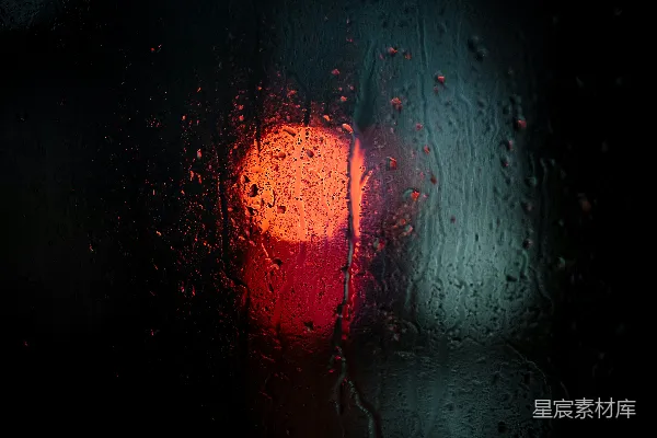 高清摄影 红灯静静地躺在蒙着雨的窗户的一侧。