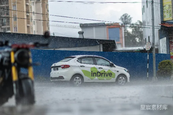 高清摄影 白色汽车在大雨中在街道上行驶。