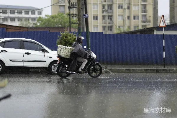 高清摄影 一个人在雨中骑摩托车前行。