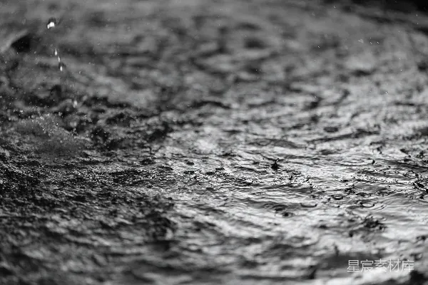 高清摄影 雨滴在暗色且有纹理的表面上形成涟漪。
