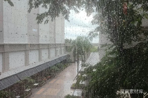 高清摄影 一扇被雨水打湿的窗户，远处是街道景色