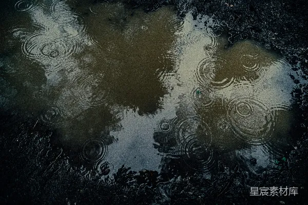 高清摄影 雨滴在泥泞的水洼中荡起涟漪，映射着天空。