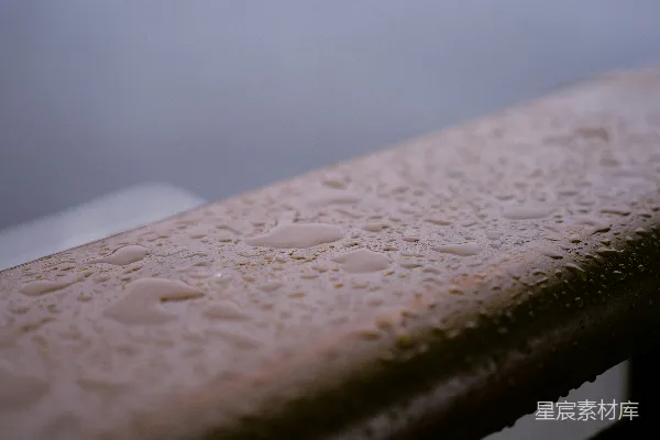 高清摄影 雨滴覆盖着一个雨天的木栏杆。