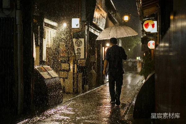 高清摄影 夜幕下一个人在雨中步行，手握伞。