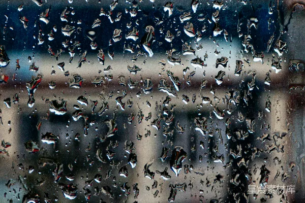 高清摄影 窗户上的雨滴与模糊的建筑物。