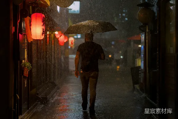 高清摄影 夜晚行人打着伞走在雨中的城市街道上