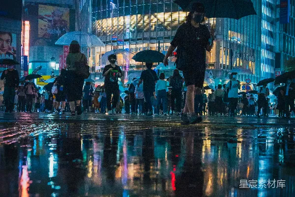 高清摄影 一群人在街上行走，手中拿着伞