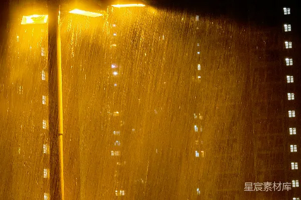 高清摄影 夜幕下，街灯在大雨中照亮一座黑暗的建筑物。