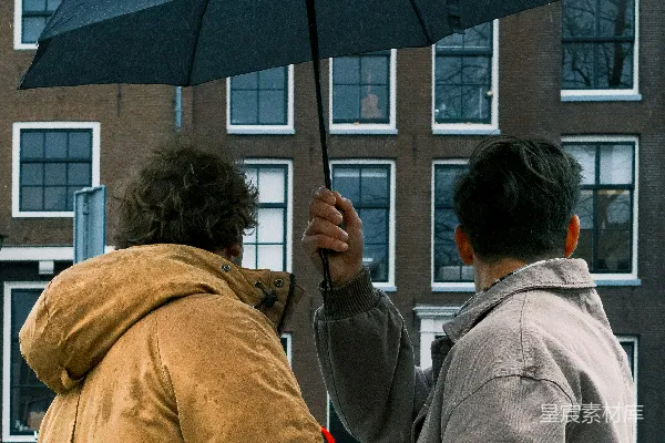 高清摄影 两人在雨中撑伞同行。