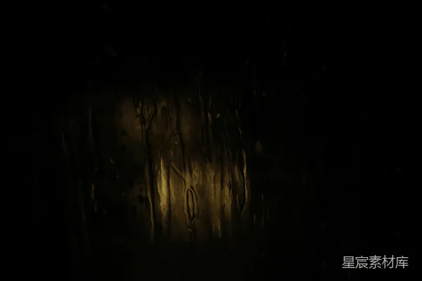 高清摄影 玻璃上雨水流淌，背后有模糊的光线。